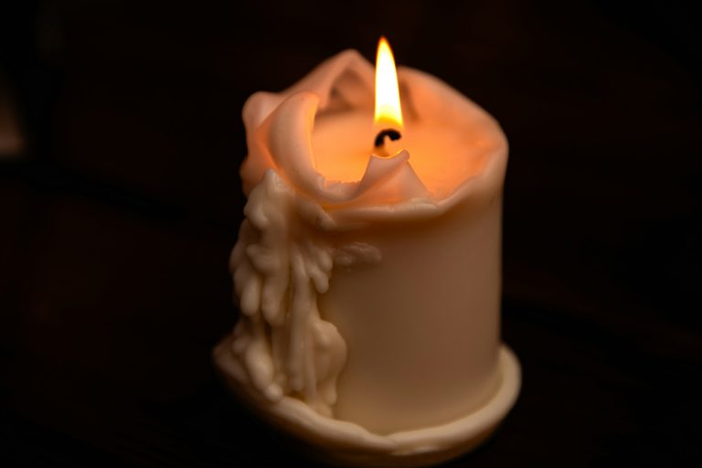 Α lit candle with melting wax drips